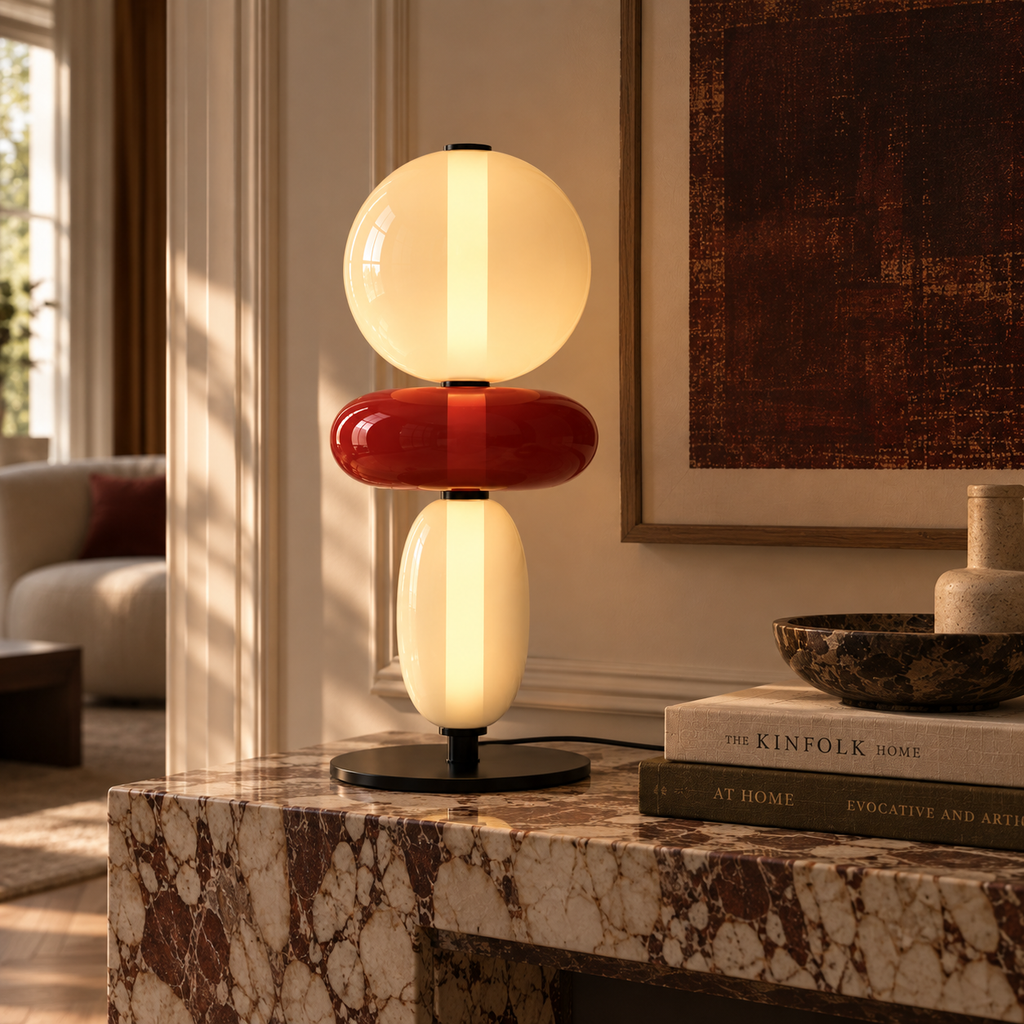 Stacked glass totem table lamp beside a bed