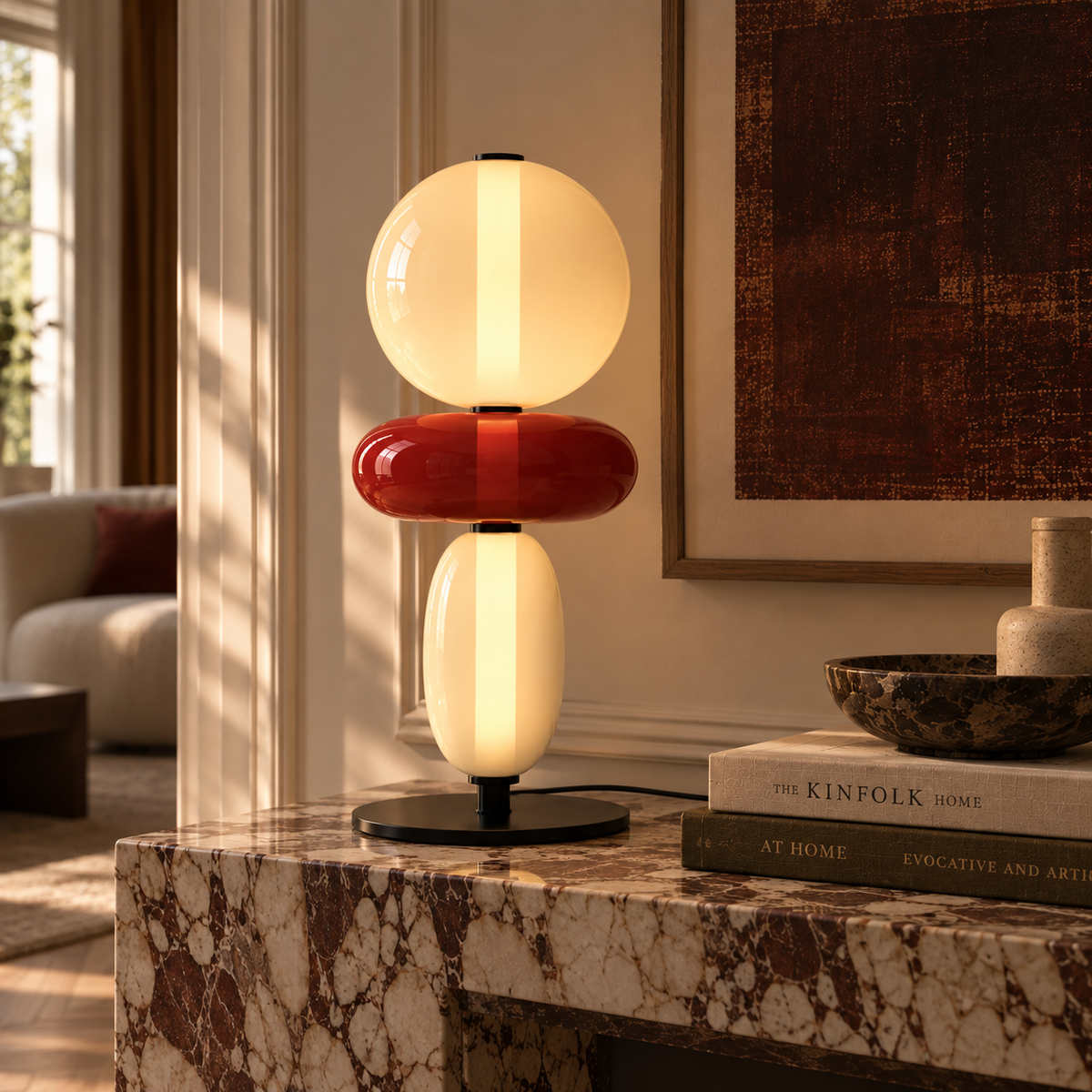 Stacked glass totem table lamp beside a bed