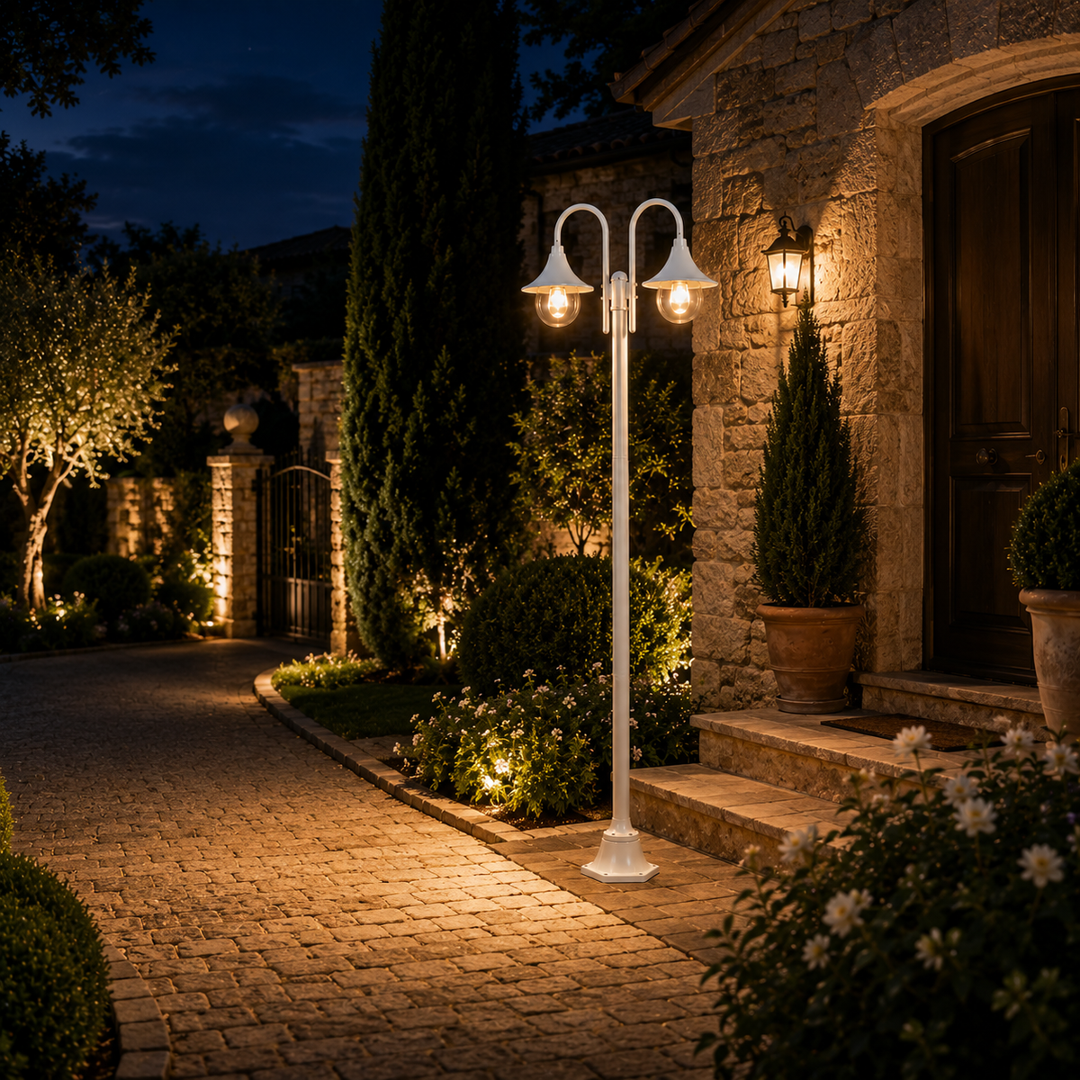 White aluminium garden lamp post lighting a stone path to the entrance