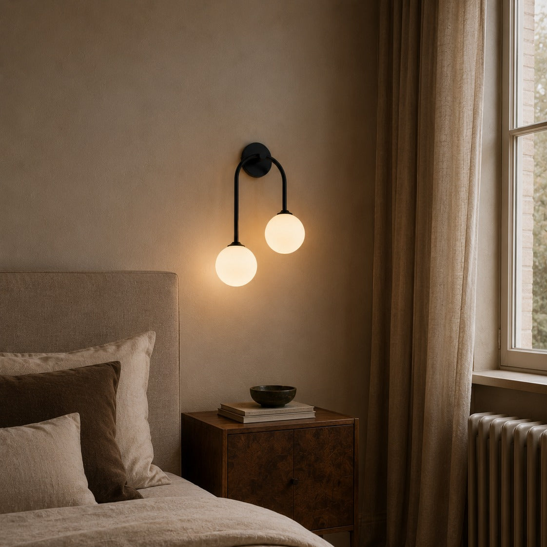Black glass ball double wall light beside a bed near a tall window in a bedroom