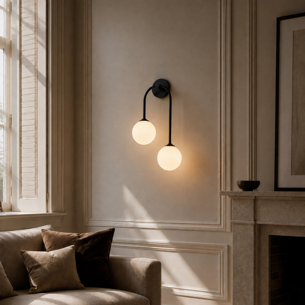 Black glass ball double wall light beside a fireplace in a period living room