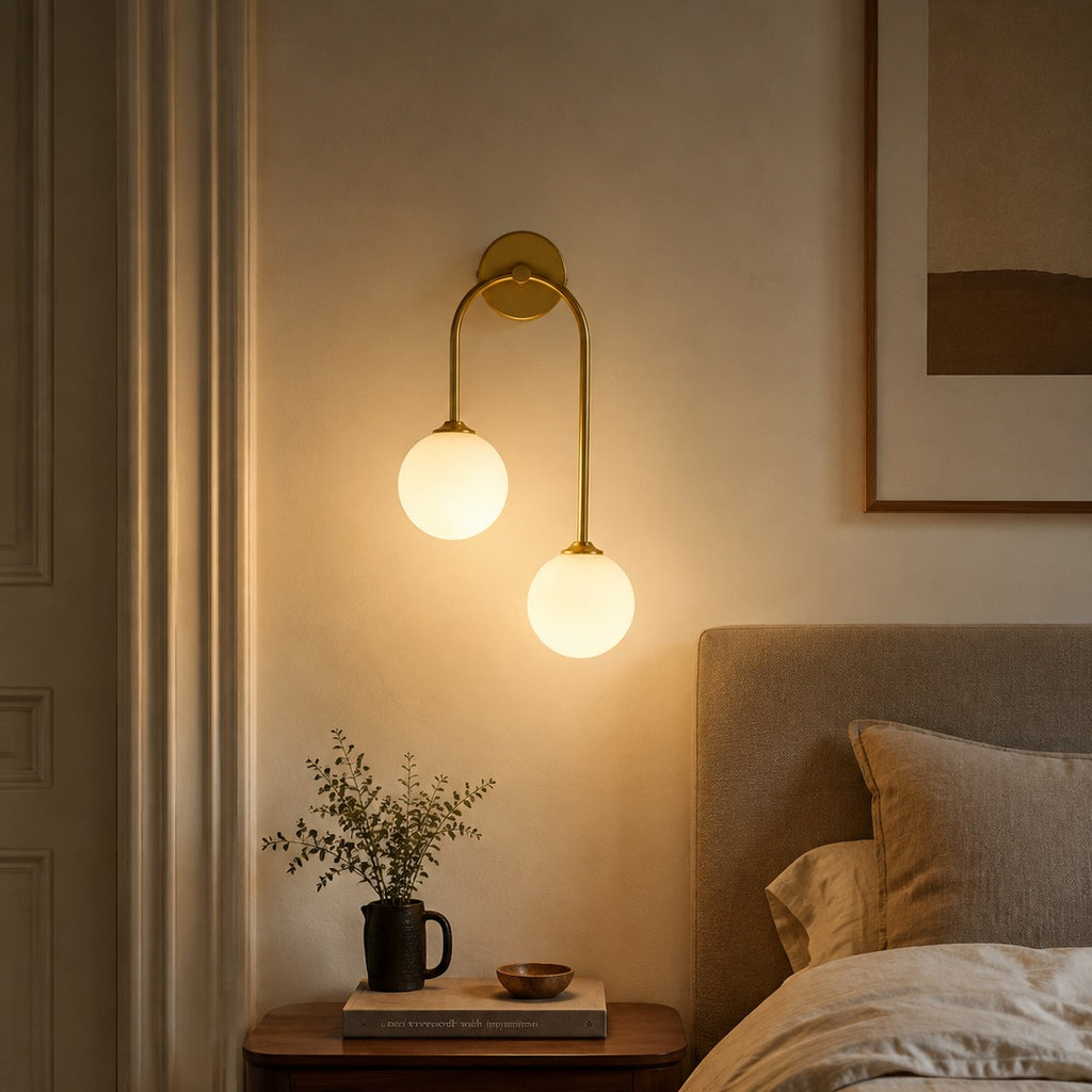 Gold glass ball double wall light above a walnut nightstand in a Nordic-style bedroom