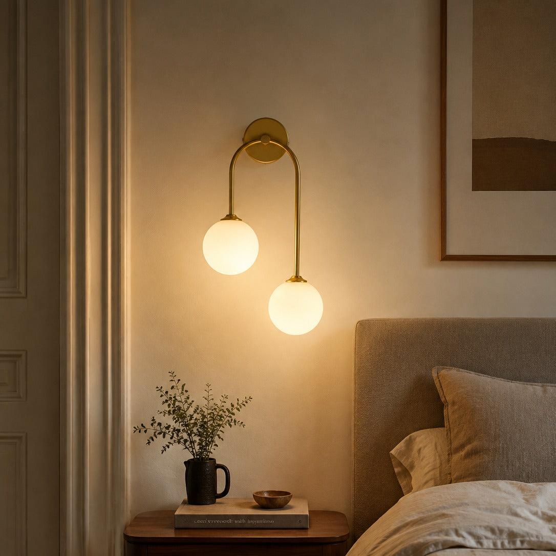 Gold glass ball double wall light above a walnut nightstand in a Nordic-style bedroom