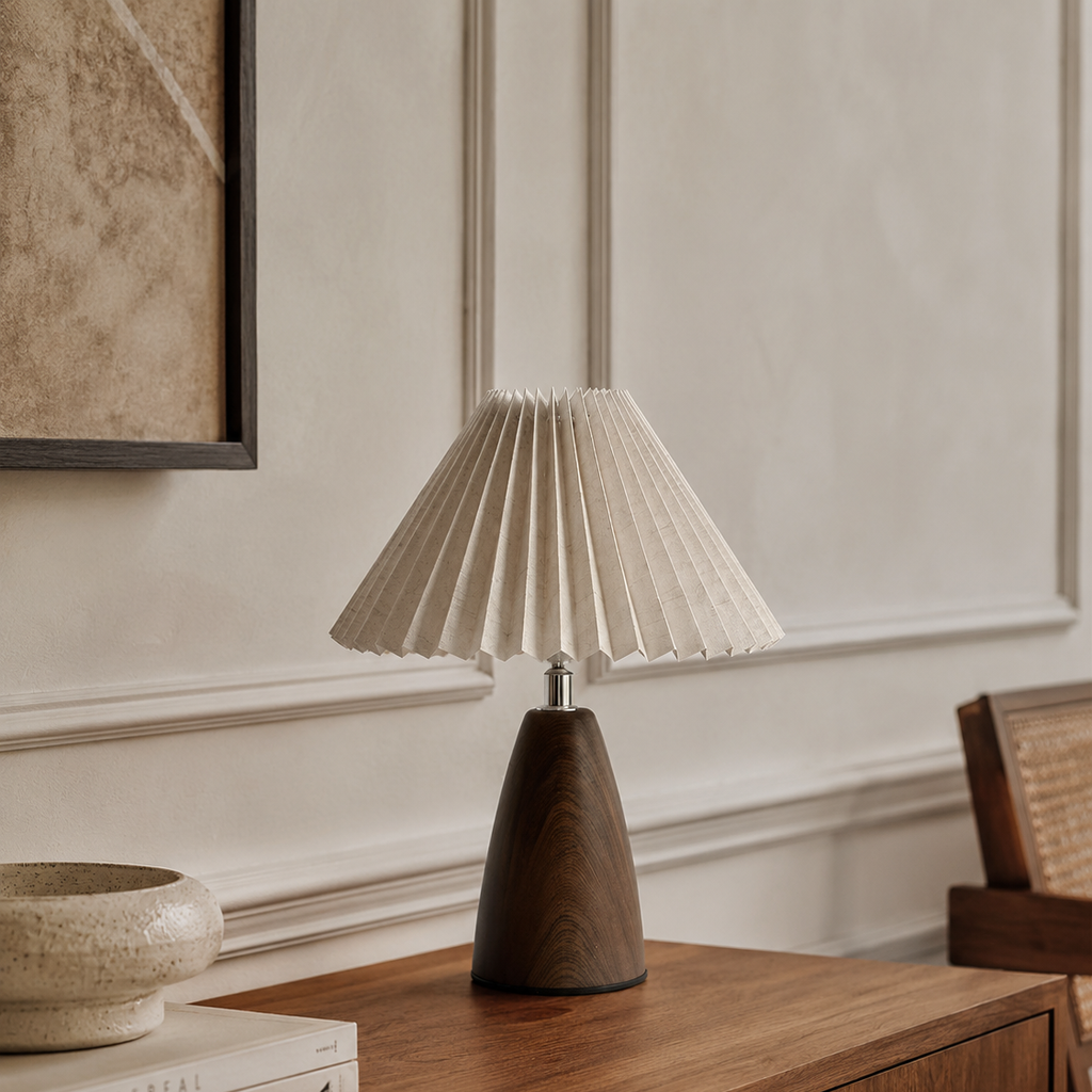 Pleated shade table lamp with a walnut base on a console table