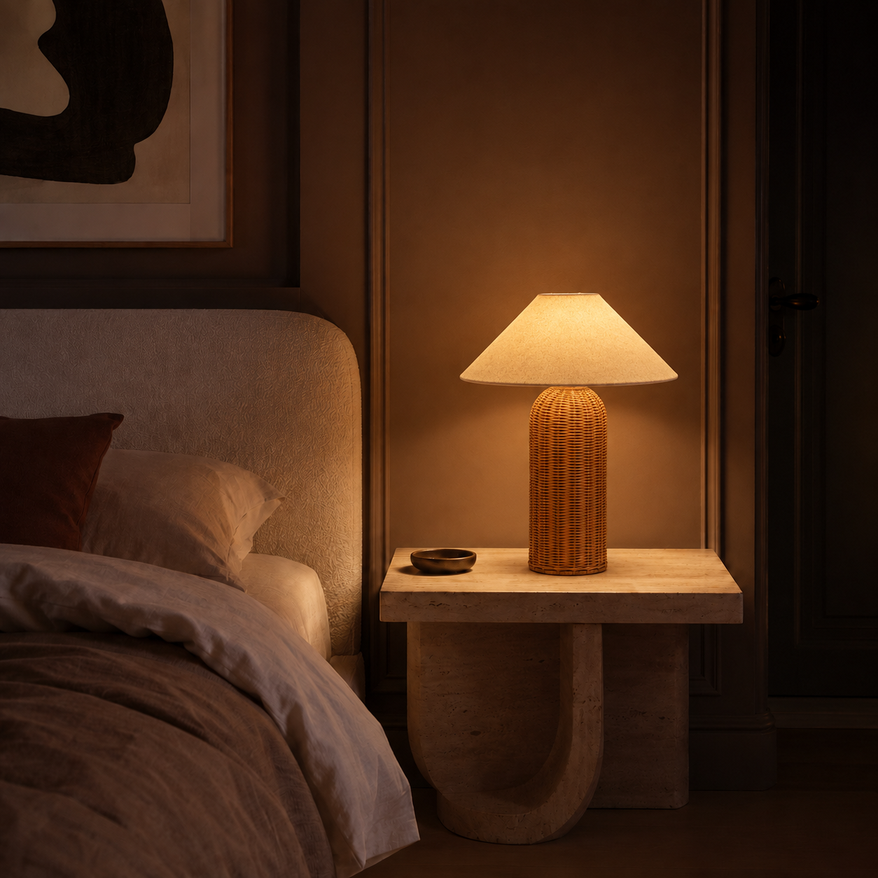 Rattan cylindrical table lamp glowing on a walnut nightstand