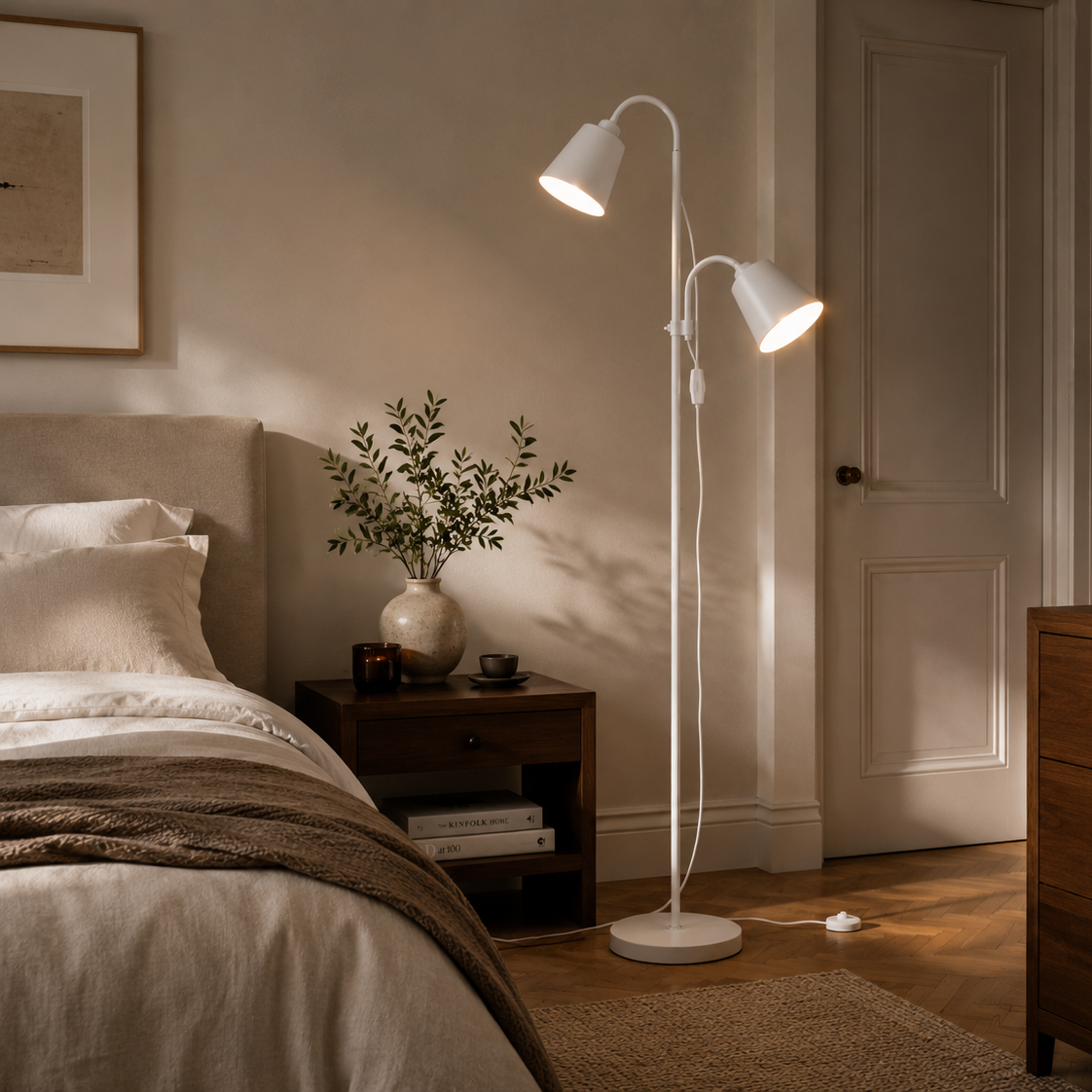 White two-head floor lamp beside the bed in a warm bedroom