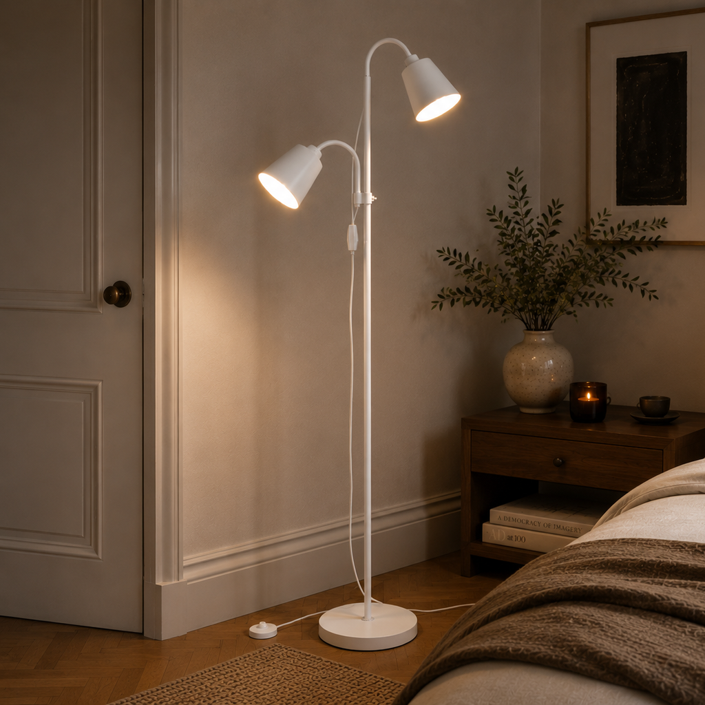 White two-head floor lamp in a bedroom corner beside a panelled door
