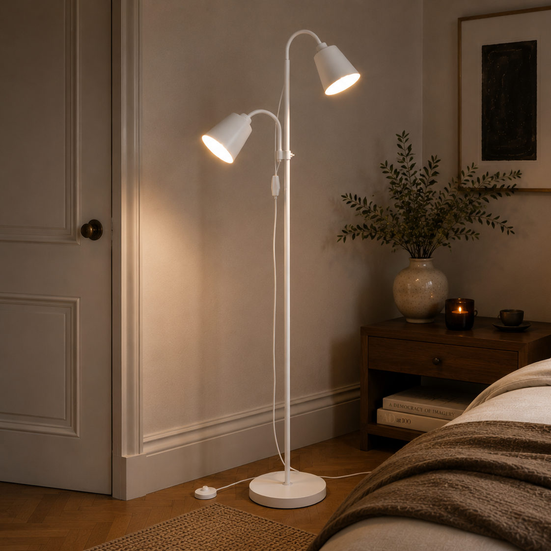 White two-head floor lamp in a bedroom corner beside a panelled door