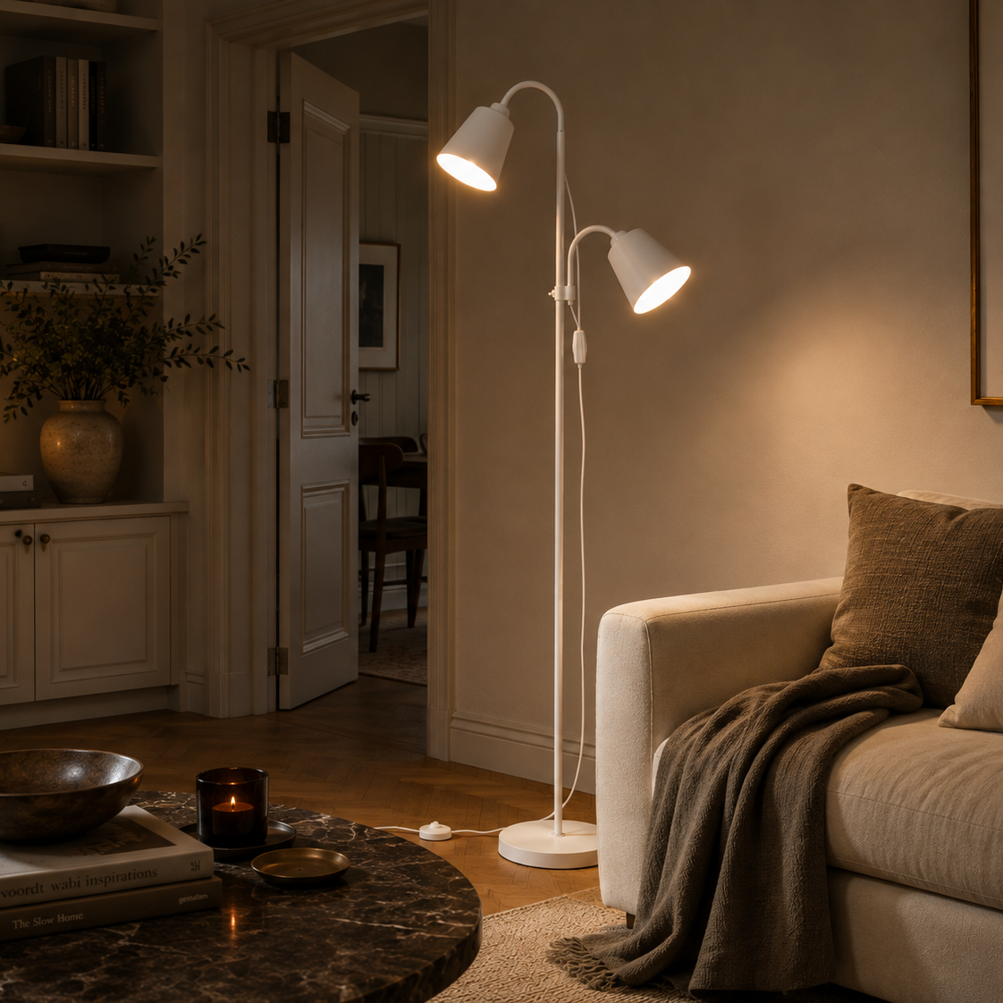 White two-head floor lamp in the corner of a living room with a marble table